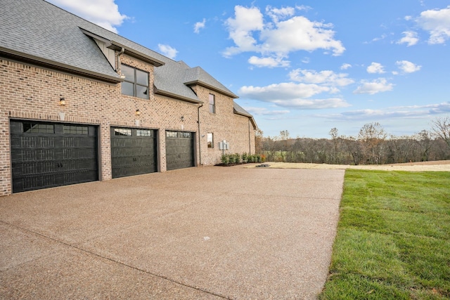 view of side of home featuring a garage and a lawn