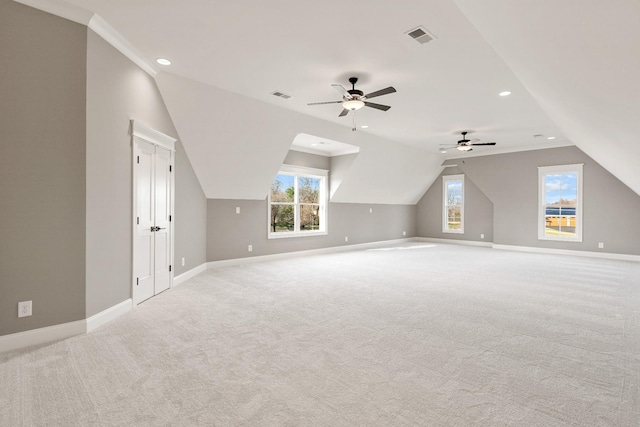 additional living space featuring vaulted ceiling, light carpet, and ceiling fan