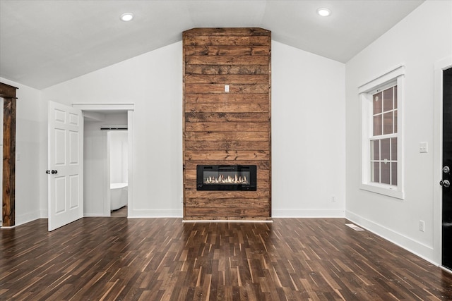 unfurnished living room featuring vaulted ceiling and dark hardwood / wood-style flooring
