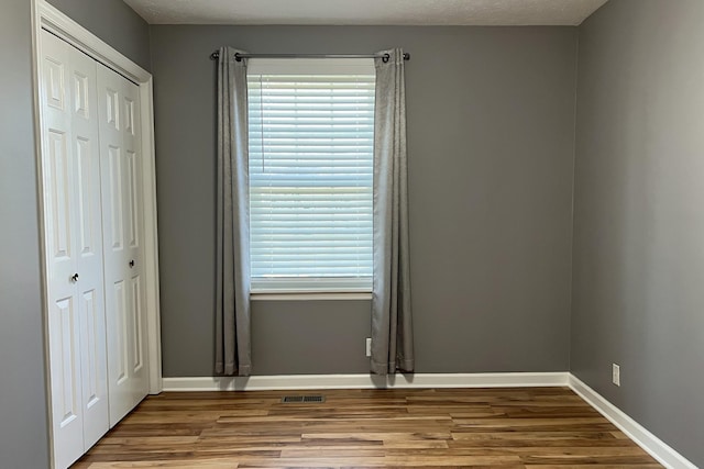 unfurnished room featuring a textured ceiling, light hardwood / wood-style flooring, and a wealth of natural light