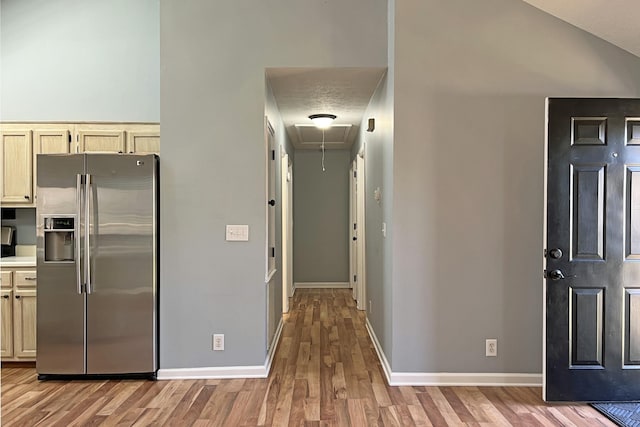 kitchen featuring stainless steel fridge, light hardwood / wood-style floors, and cream cabinetry