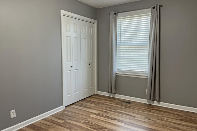 unfurnished bedroom featuring light hardwood / wood-style floors and a closet