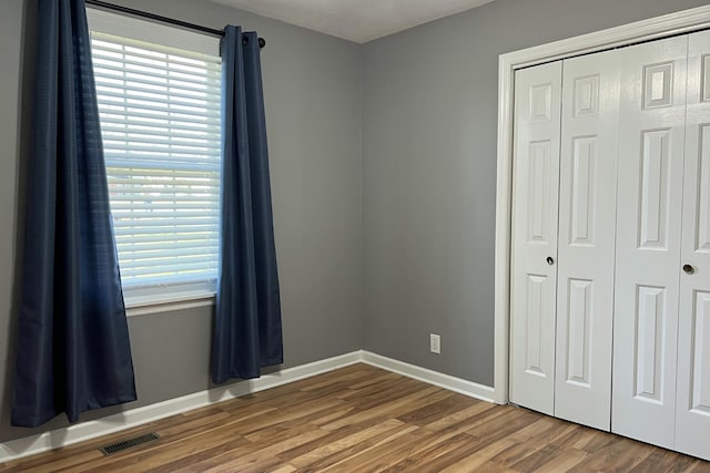 unfurnished bedroom with wood-type flooring and a closet