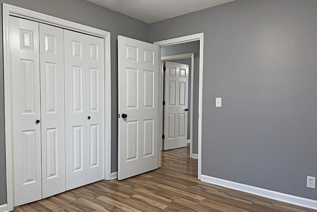 unfurnished bedroom featuring hardwood / wood-style floors and a closet