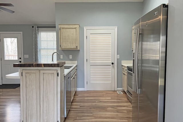 kitchen featuring sink, light hardwood / wood-style flooring, ceiling fan, and appliances with stainless steel finishes