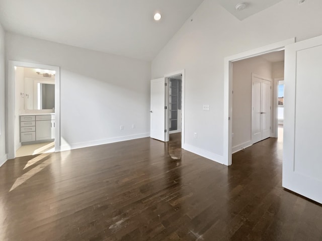 empty room with high vaulted ceiling and dark hardwood / wood-style floors