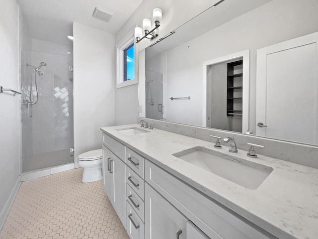 bathroom with vanity, tile patterned flooring, a shower with door, and toilet