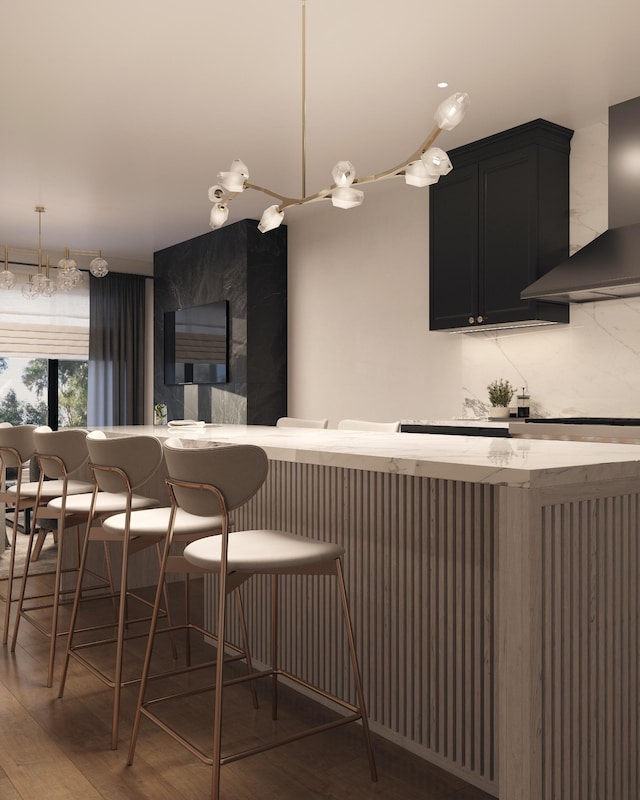 kitchen with hardwood / wood-style floors, decorative backsplash, a kitchen breakfast bar, and wall chimney exhaust hood