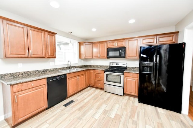 kitchen featuring recessed lighting, a sink, visible vents, light wood-type flooring, and black appliances