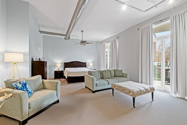 carpeted bedroom featuring access to exterior, rail lighting, and ceiling fan