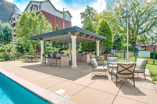 view of patio / terrace featuring a gazebo, area for grilling, a community pool, a grill, and exterior bar