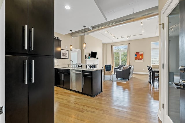 kitchen featuring sink, light hardwood / wood-style flooring, dishwasher, hanging light fixtures, and built in fridge