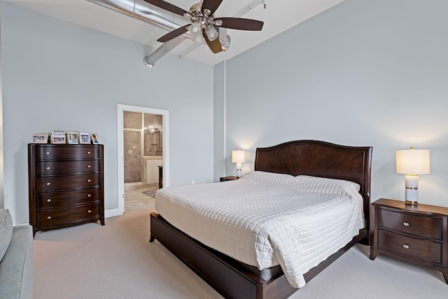 carpeted bedroom with ceiling fan and ensuite bath