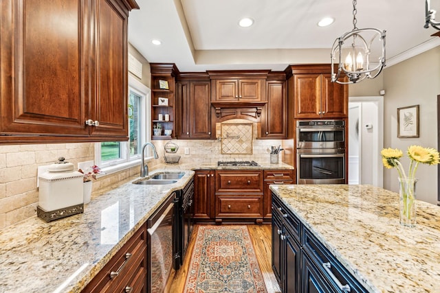 kitchen featuring pendant lighting, sink, appliances with stainless steel finishes, light stone countertops, and light wood-type flooring