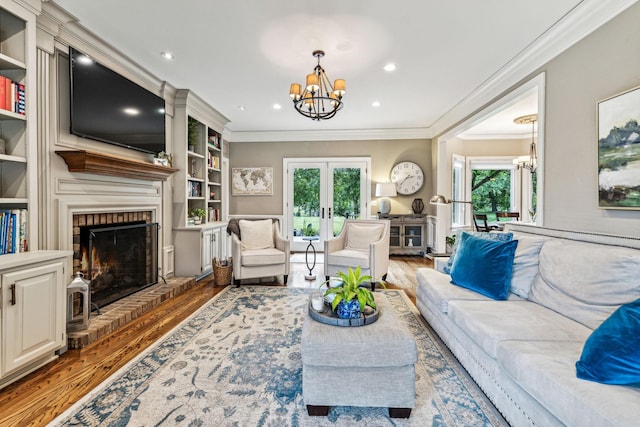 living room featuring hardwood / wood-style floors, ornamental molding, and a chandelier