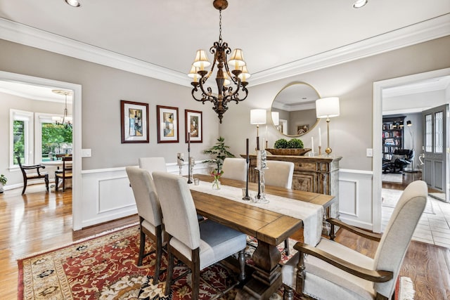 dining room featuring an inviting chandelier, hardwood / wood-style floors, and ornamental molding