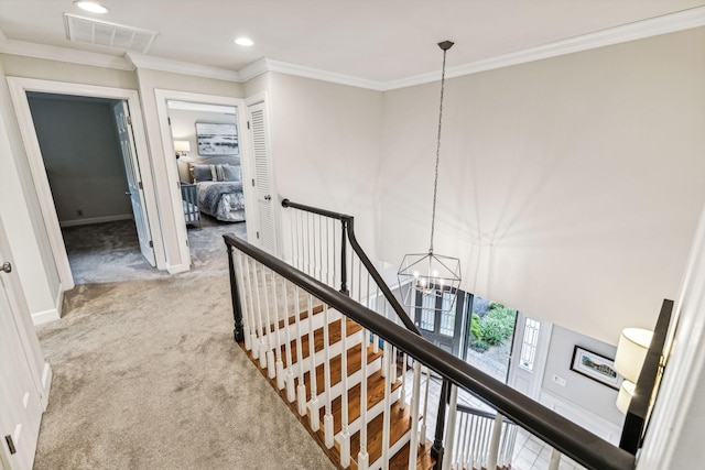 corridor featuring a notable chandelier, crown molding, and light colored carpet