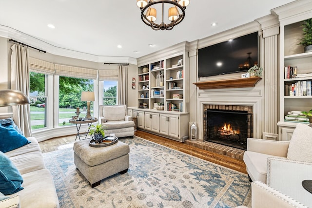 living room featuring hardwood / wood-style flooring, crown molding, a fireplace, and built in shelves