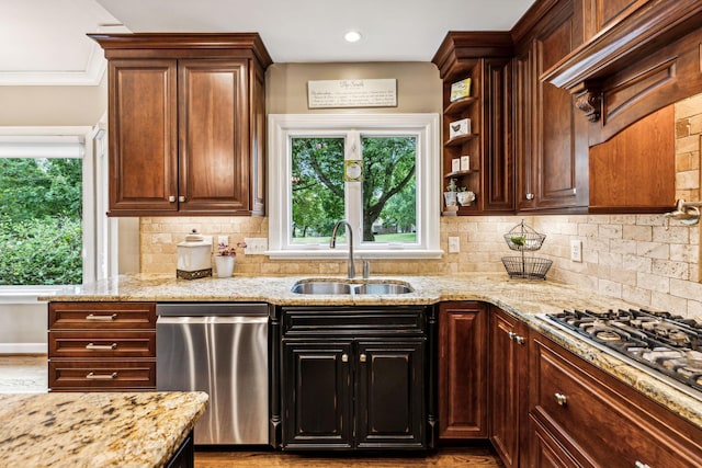 kitchen with dark brown cabinetry, sink, light stone counters, tasteful backsplash, and appliances with stainless steel finishes