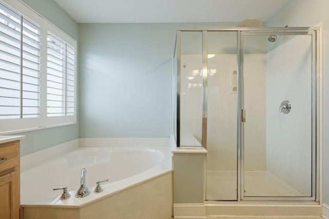 bathroom featuring vanity and independent shower and bath