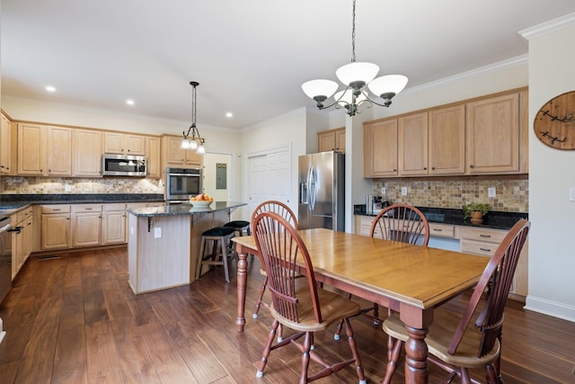 dining area featuring crown molding, dark hardwood / wood-style floors, and an inviting chandelier