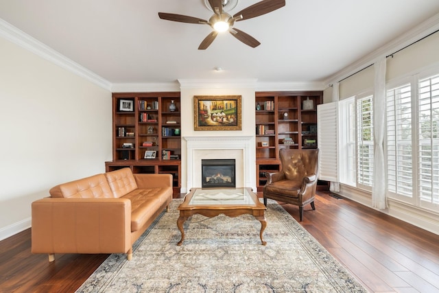 living room with dark wood-type flooring, ornamental molding, and ceiling fan