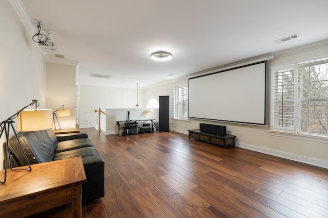 cinema room with crown molding and dark wood-type flooring