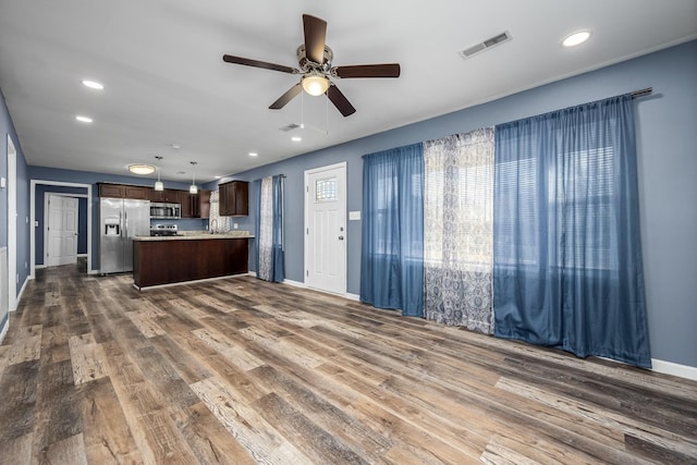 kitchen featuring hanging light fixtures, appliances with stainless steel finishes, dark hardwood / wood-style floors, and ceiling fan