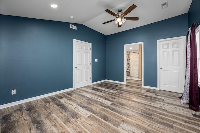 unfurnished bedroom featuring hardwood / wood-style flooring, ensuite bath, ceiling fan, and vaulted ceiling