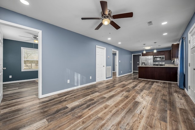 unfurnished living room featuring dark wood-type flooring, ceiling fan, and sink