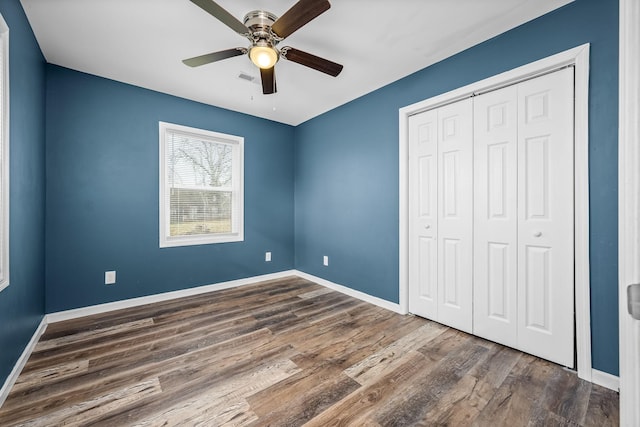 unfurnished bedroom featuring a closet, dark hardwood / wood-style floors, and ceiling fan