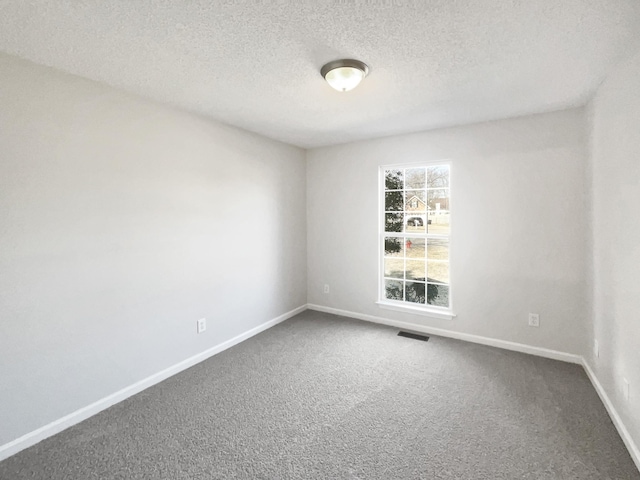 carpeted spare room with a textured ceiling