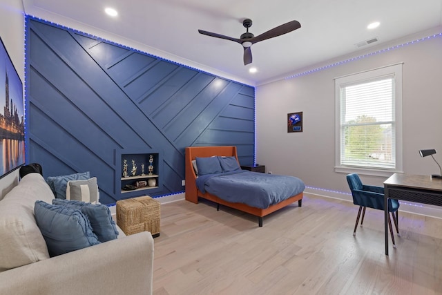 bedroom featuring crown molding, light hardwood / wood-style flooring, and ceiling fan