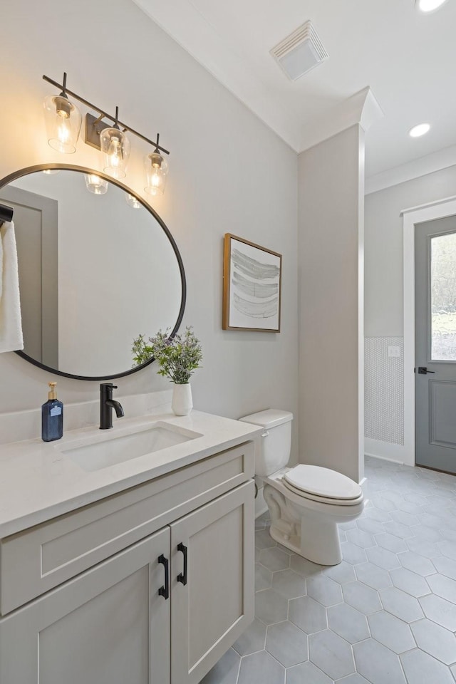 bathroom featuring vanity, ornamental molding, tile patterned floors, and toilet