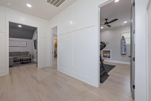 hall with crown molding and light hardwood / wood-style flooring