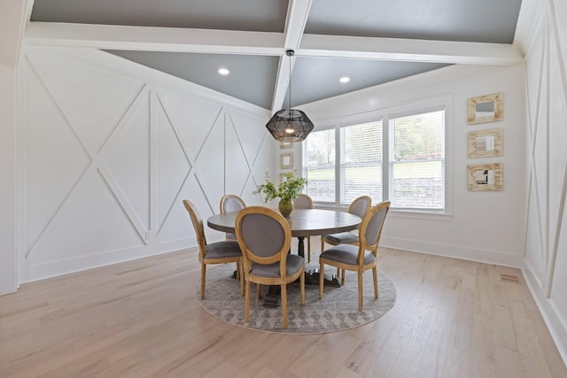 dining room with light hardwood / wood-style floors and beamed ceiling