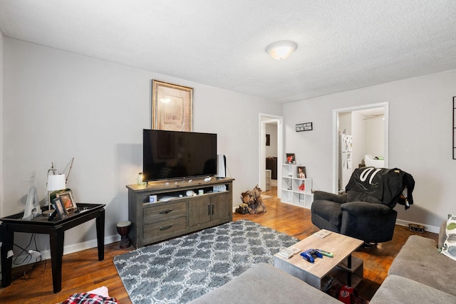 living room with dark wood-type flooring and a textured ceiling