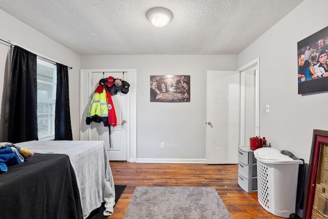 bedroom featuring dark hardwood / wood-style flooring and a textured ceiling