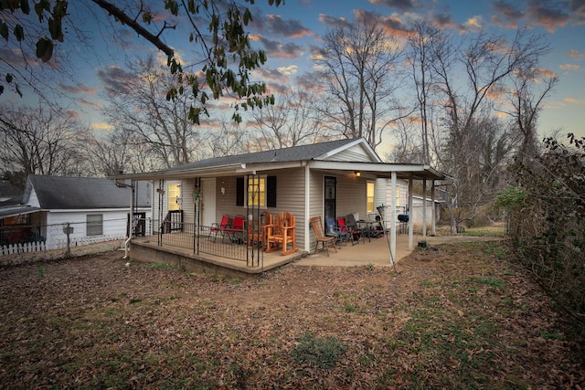 back house at dusk featuring a patio area