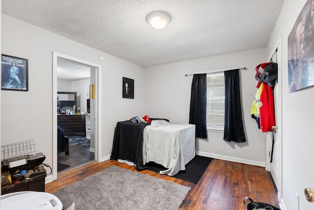 bedroom with dark hardwood / wood-style flooring and a textured ceiling