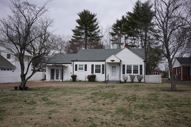 single story home featuring french doors, fence, a chimney, and a front lawn