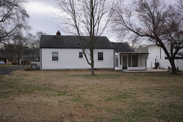 rear view of house featuring a shingled roof, a chimney, crawl space, a yard, and a patio area