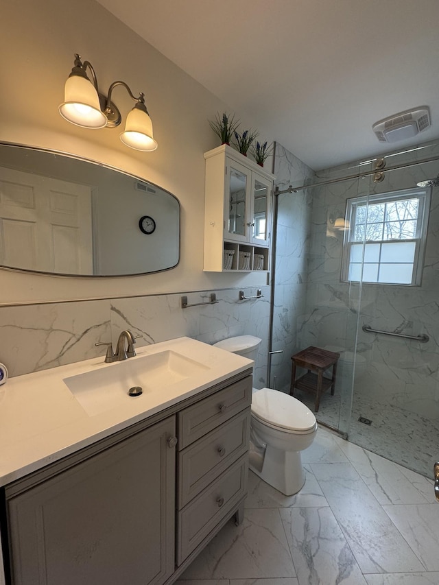 full bath featuring marble finish floor, a marble finish shower, visible vents, toilet, and vanity