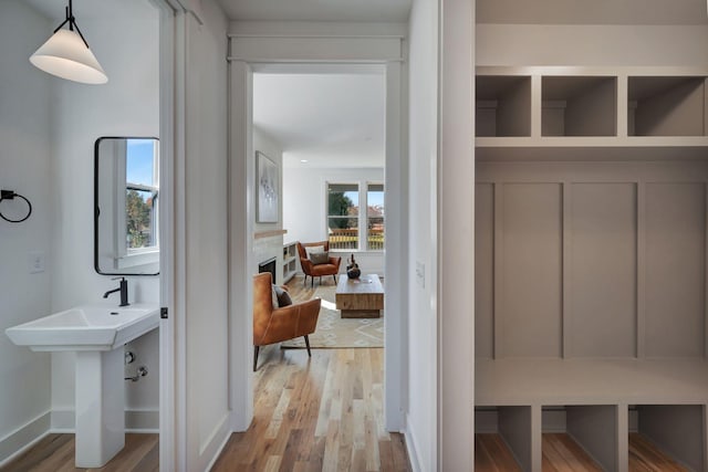 mudroom with sink and light hardwood / wood-style flooring