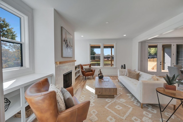 living room with light hardwood / wood-style flooring, a fireplace, and french doors