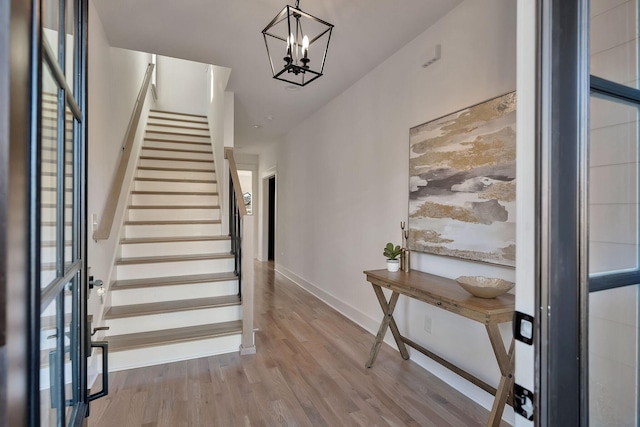 entrance foyer with wood-type flooring and a notable chandelier