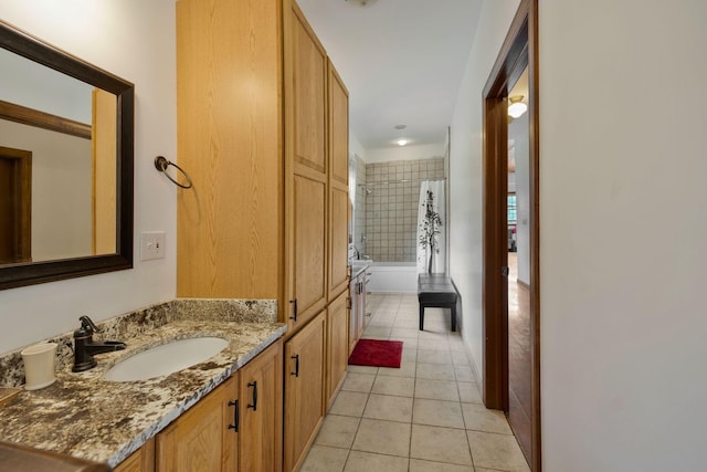 bathroom with tiled shower / bath, vanity, and tile patterned flooring