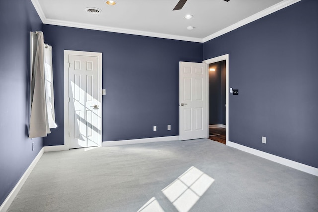 carpeted spare room featuring ceiling fan and ornamental molding