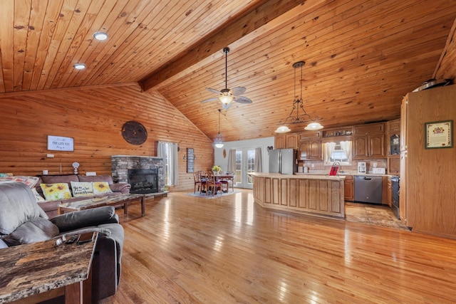 living room featuring beam ceiling, a stone fireplace, wooden ceiling, and light wood-type flooring