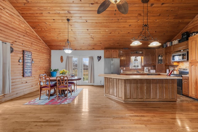 kitchen with pendant lighting, stainless steel appliances, and lofted ceiling